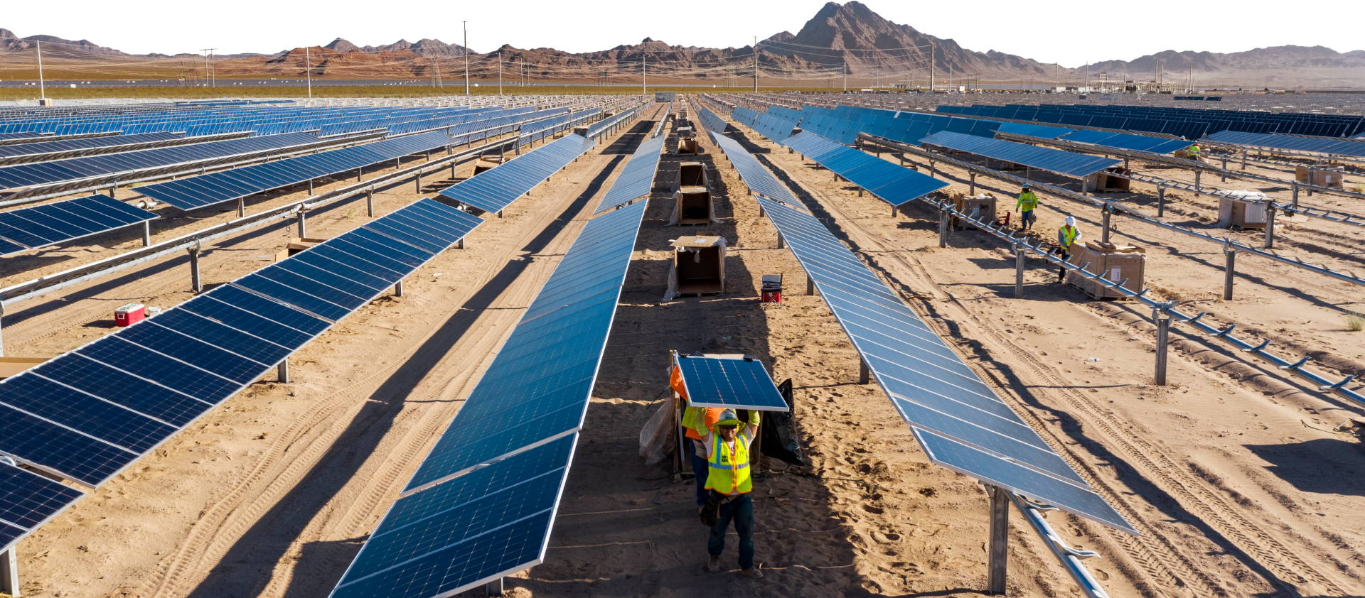 An array of solar panels being installed in the desert